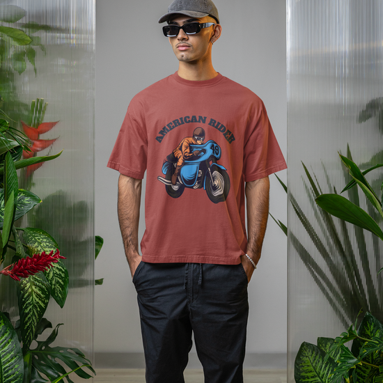 Model wearing coral oversized unisex t-shirt with "American Rider" graphic – Thodacrazyclub