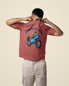 Model wearing coral oversized unisex t-shirt with "American Rider" graphic – Thodacrazyclub